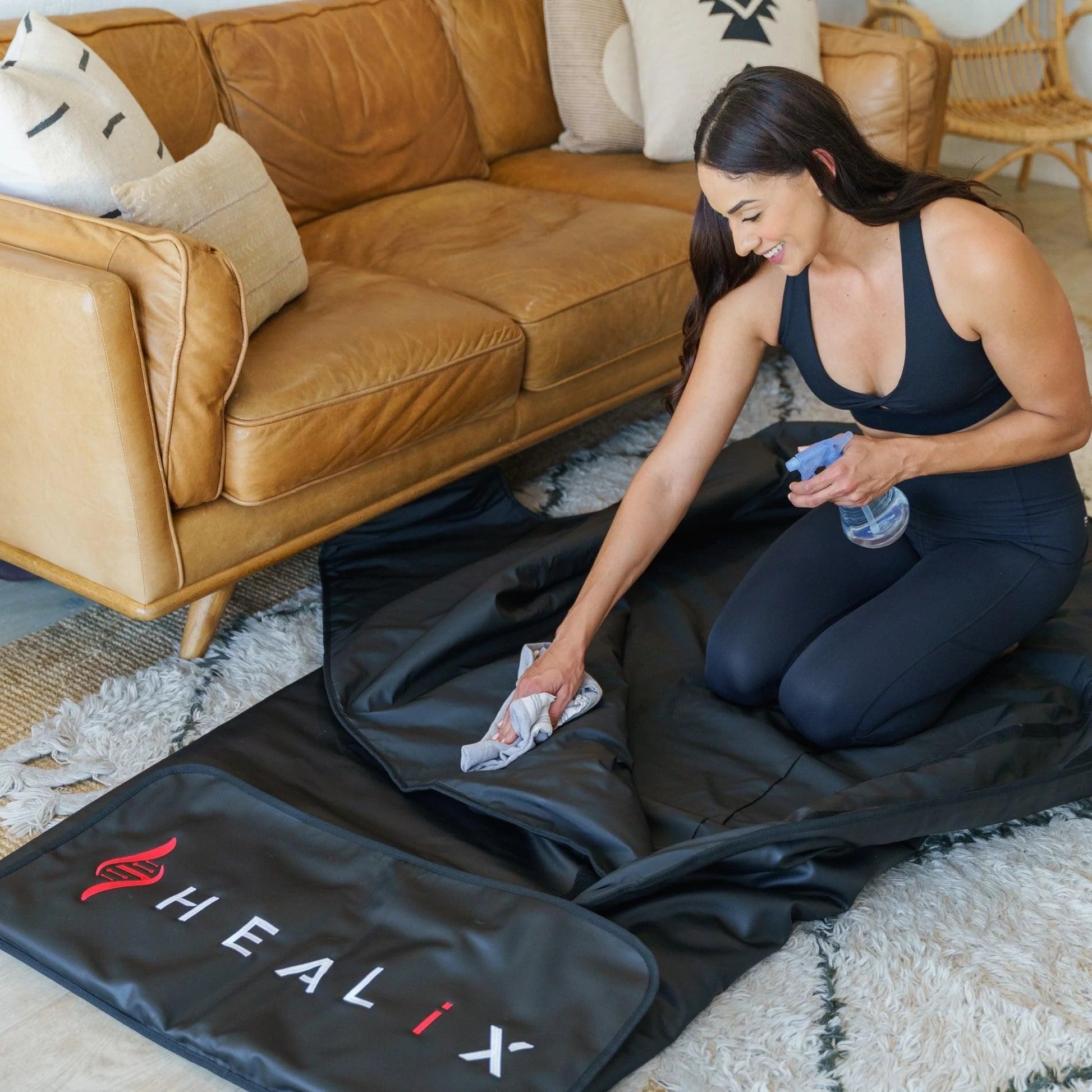 Woman cleaning her infrared sauna blanket in living room setting