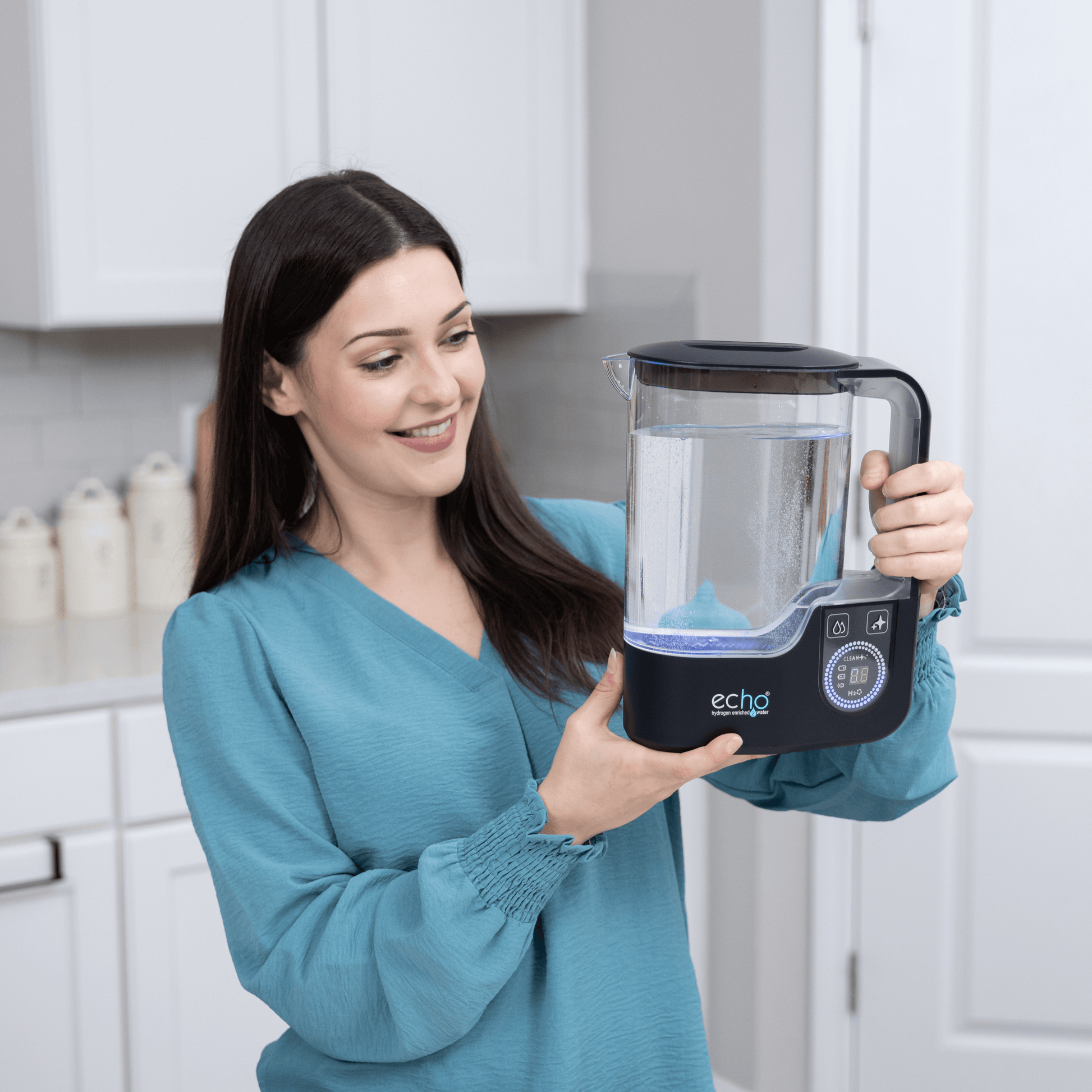 Woman holding Echo Hydrogen Water Pitcher in a kitchen setting, showcasing its advanced molecular hydrogen technology.