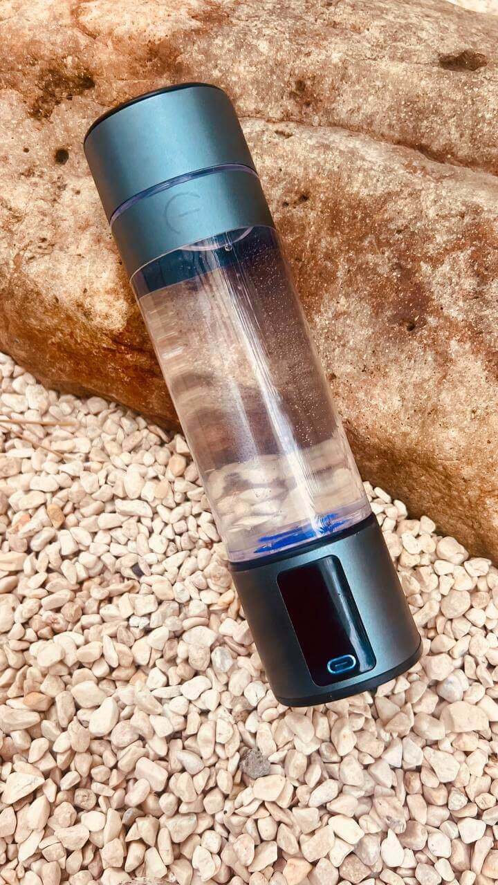 Lumivitae Cell Power Hydrogen Water Bottles by a waterfall, showcasing ergonomic design and advanced hydrogen infusion technology.