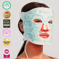 Woman using Omnilux Contour Face LED mask for anti-aging therapy with awards displayed, best red light therapy mask in Canada.