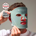 Man wearing Omnilux Red Light Therapy Mask for Men, an FDA-cleared LED mask for rejuvenating skin, featured with award logos.