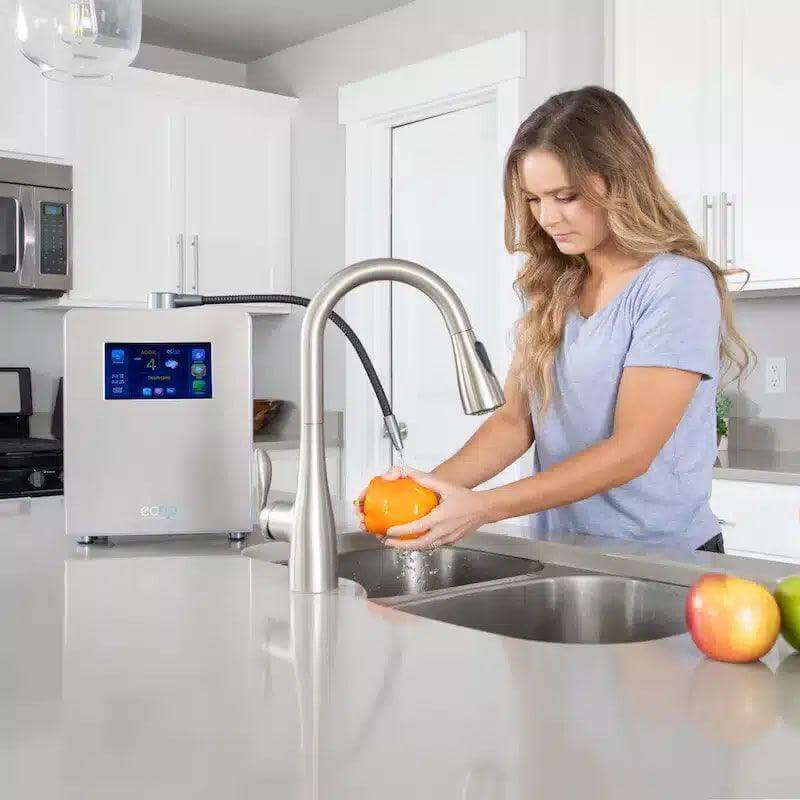 Woman using the Echo Ultimate Hydrogen Water Machine in kitchen for enriched water benefits