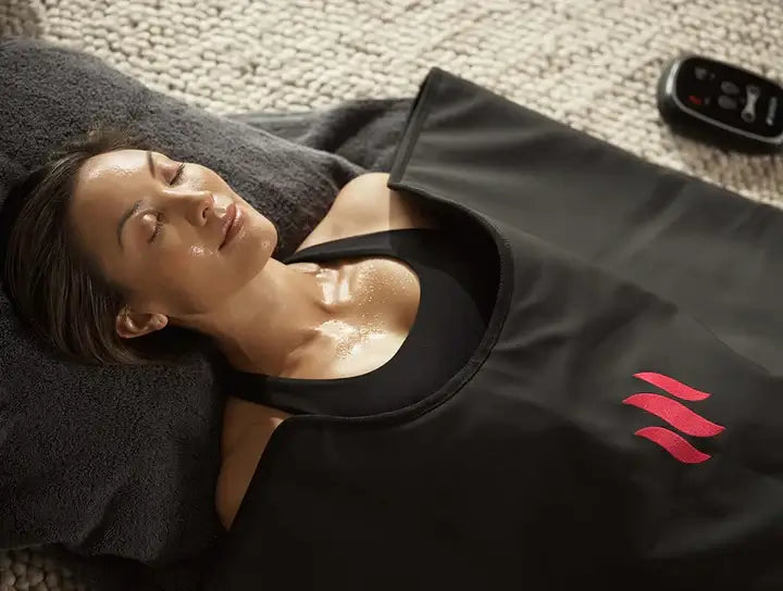 Woman relaxing in MiHigh Infrared Sauna Blanket for at-home wellness therapy.