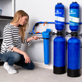 Woman installing Aquasana Rhino Whole House Water Filter System for well water filtration.