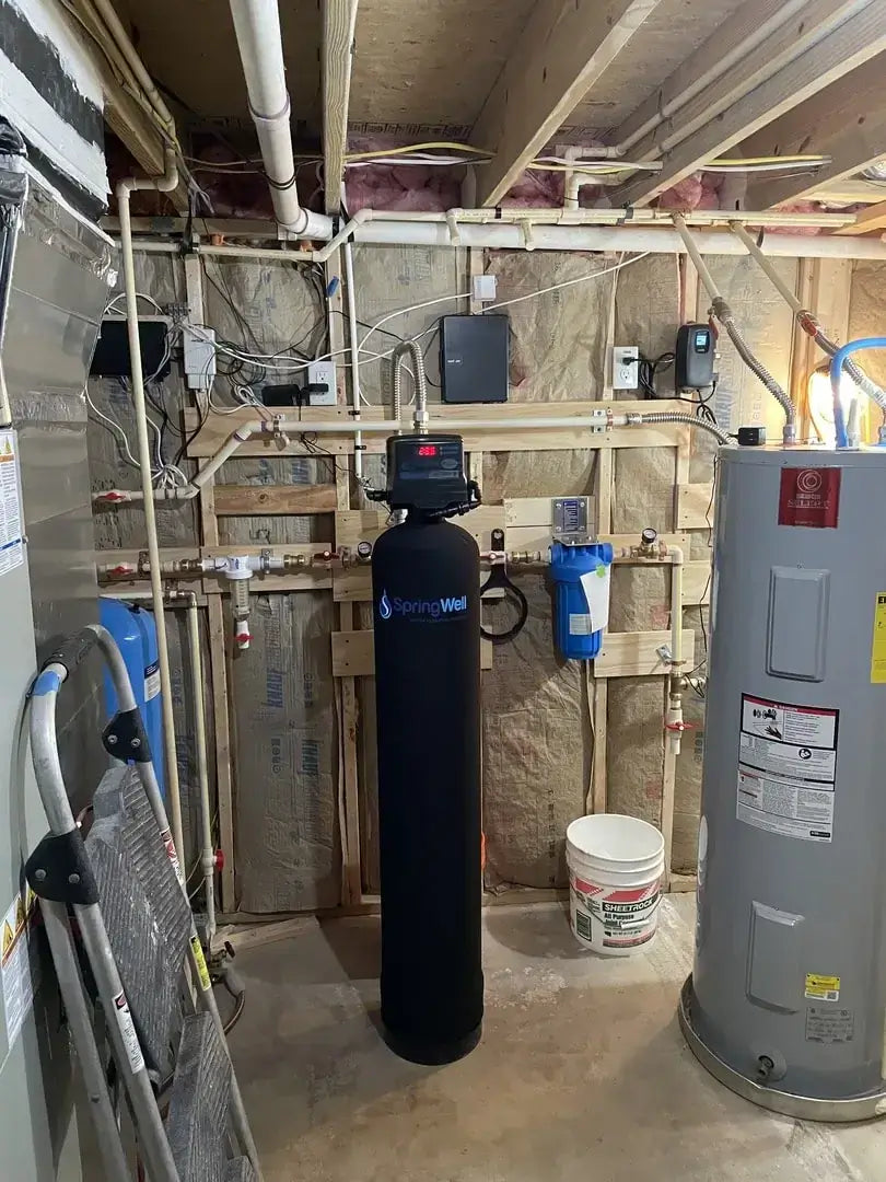 SpringWell Whole House Iron Filter for Well Water installed in a basement, part of a comprehensive filtration system setup.